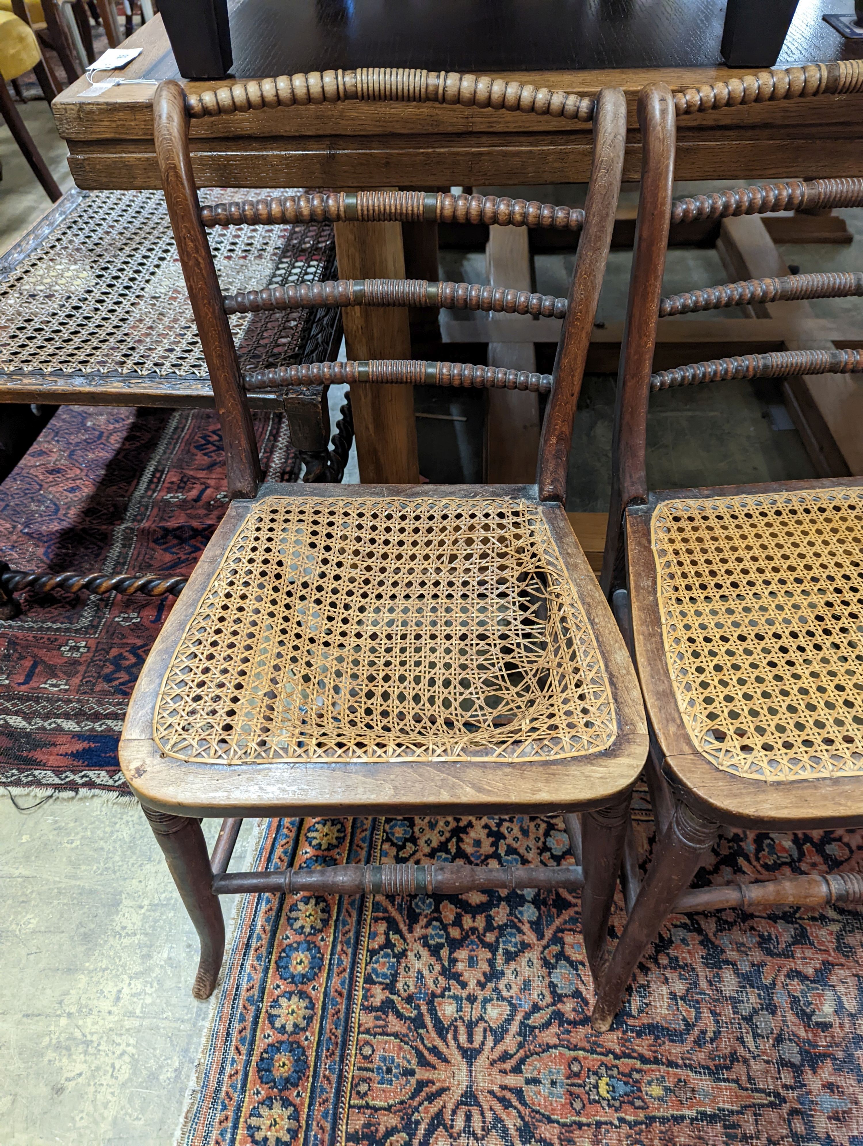 A set of three Regency provincial simulated rosewood cane seated dining chairs